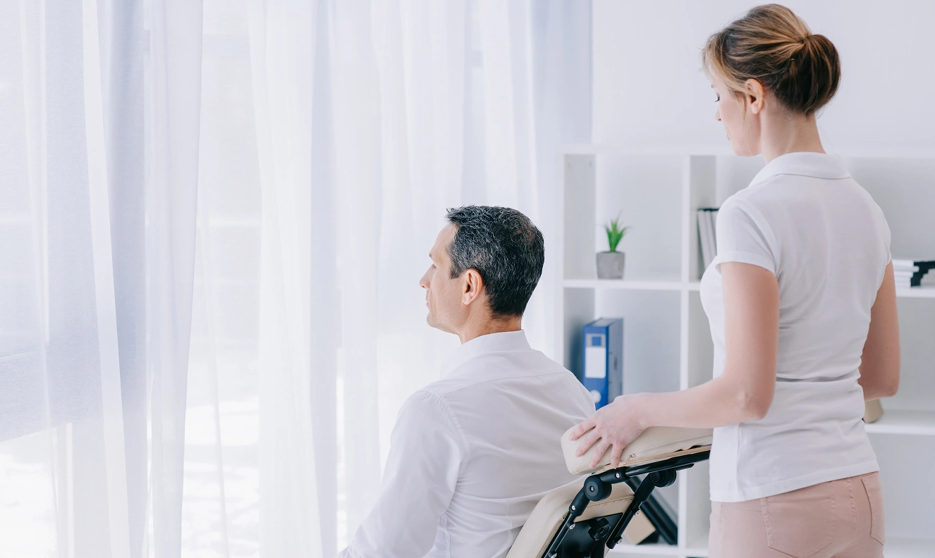 a2z chiropractic businessman sitting on massage chair with masseuse